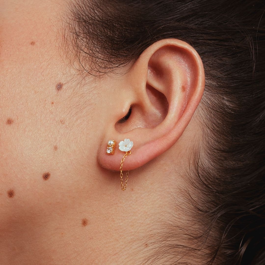 Boucles d'oreilles asymétriques pour femme. Argent 925 et dorées à l'or fin jaune. Perle blanches et fleur blanche en nacre. Boucle d'oreilles pendantes. Boucles d'oreilles chaine Les Joyaux d'Auré