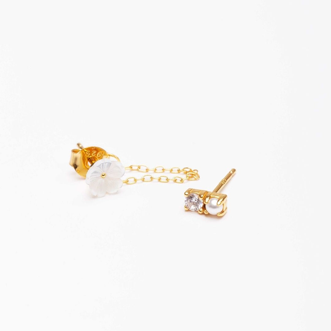 Boucles d'oreilles asymétriques pour femme. Argent 925 et dorées à l'or fin jaune. Perle blanches et fleur blanche en nacre. Boucle d'oreilles pendantes. Boucles d'oreilles chaine Les Joyaux d'Auré
