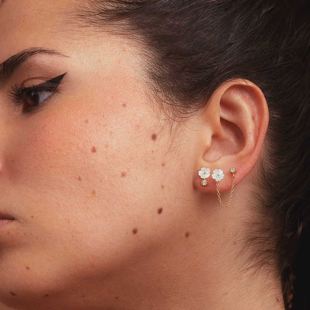 Boucles d'oreilles asymétriques pour femme. Argent 925 et dorées à l'or fin jaune. Perle blanches et fleur blanche en nacre. Boucle d'oreilles pendantes. Boucles d'oreilles chaine Les Joyaux d'Auré