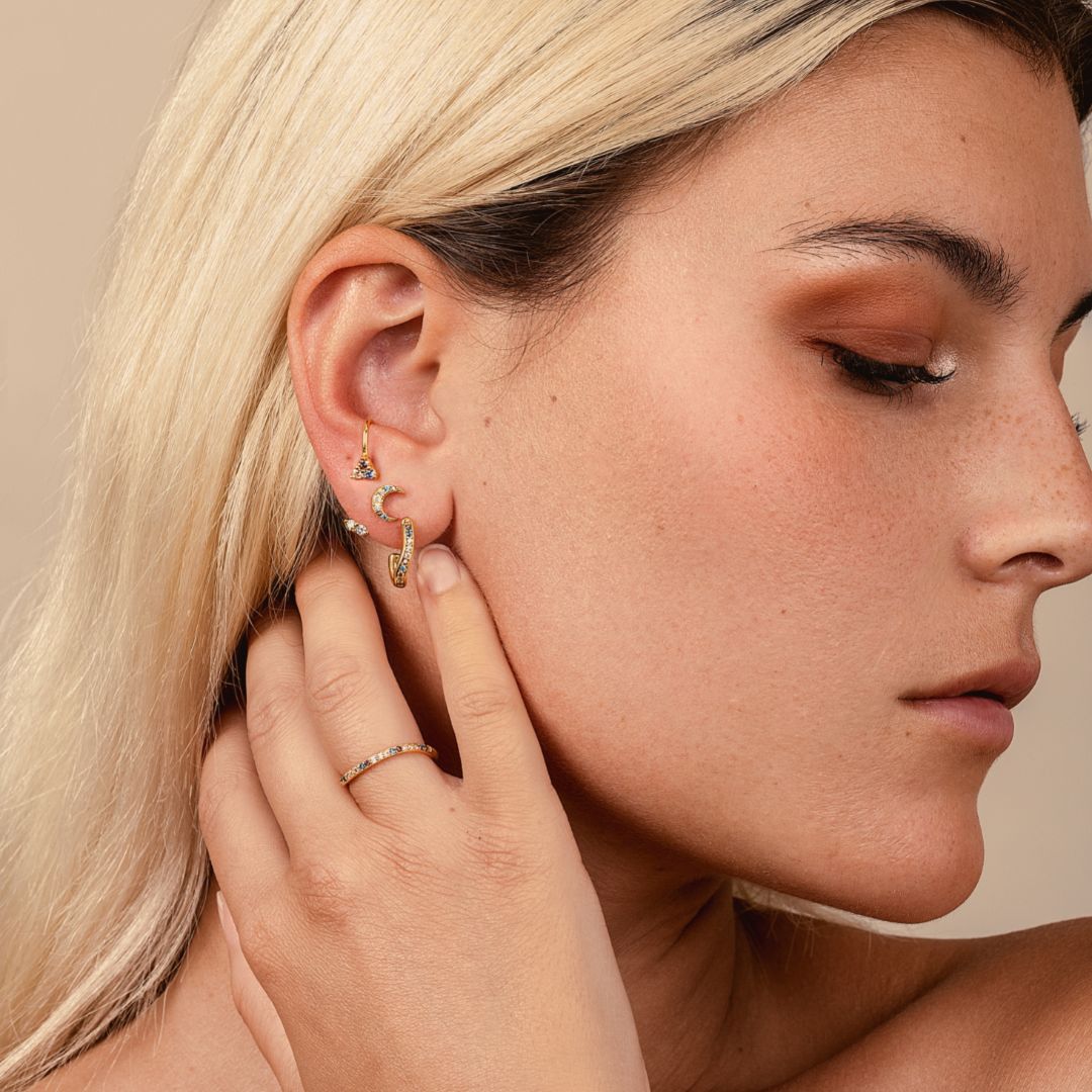 Créoles femme dorées et pierres. Boucles d'oreilles dorées à l'or fin Les Joyaux d'Auré. Pierres bleues, marrons et blanches. Compositions de piercings et boucles d'oreilles